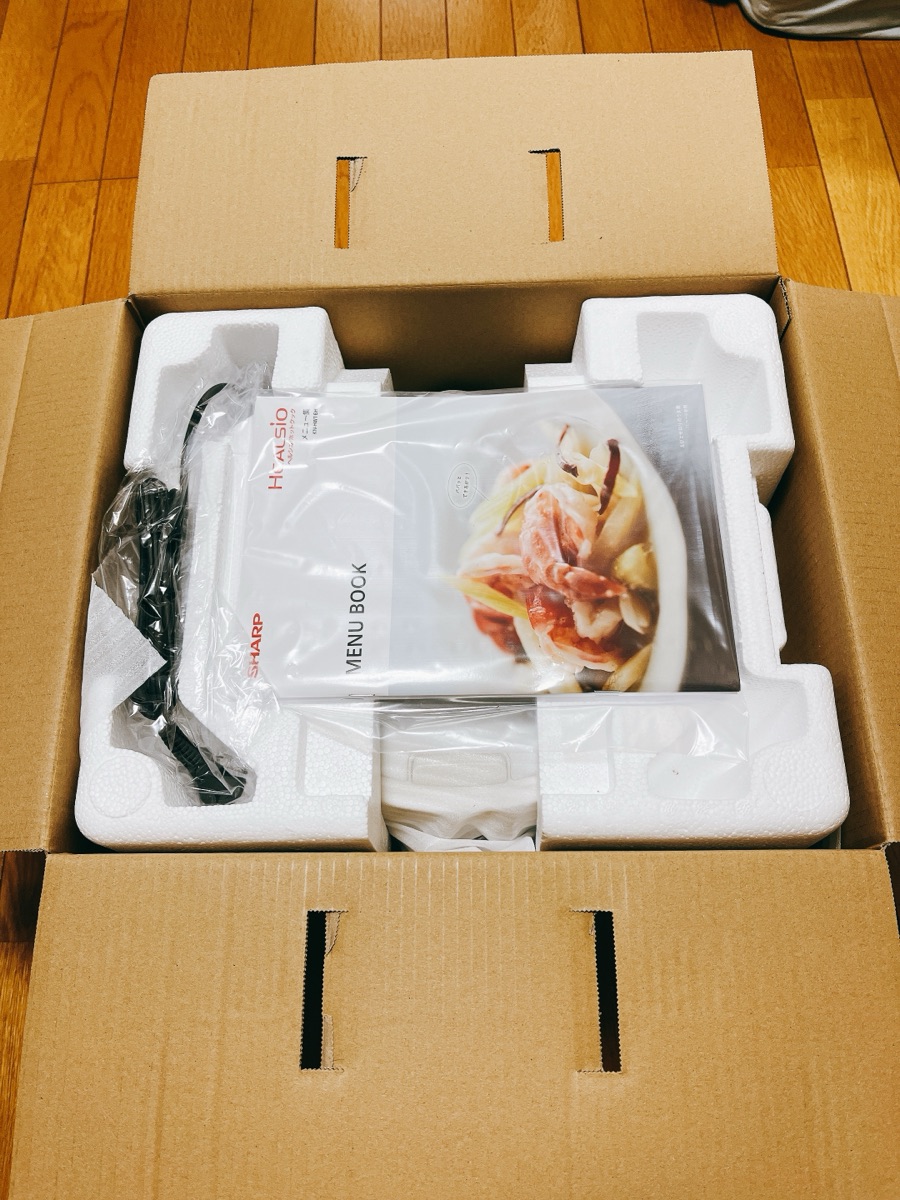 レンタルで届いた新品ホットクックの箱を開けたところ。SHARPのメニューブックが入っている
